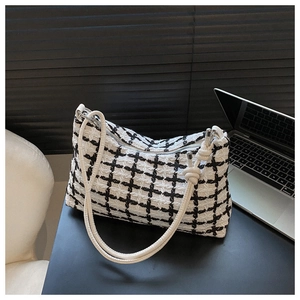 Close-up of black and white plaid tweed shoulder bag with unique knotted strap detail