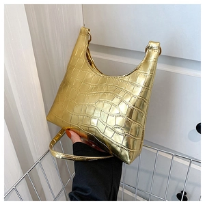 Close-up of golden croc-embossed handbag showing metallic finish and hardware