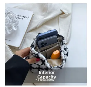 Top view of houndstooth bucket bag interior holding smartphones, card holder and cosmetics