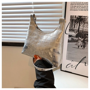 Detail of silver metallic hobo bag featuring crocodile pattern and minimalist design