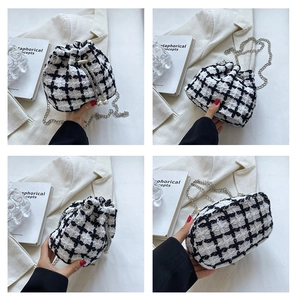Detail views of black and white houndstooth tweed bucket bag with pearl chain strap