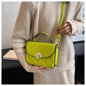 Side view of a bright yellow quilted crossbody bag on model for stylish size reference