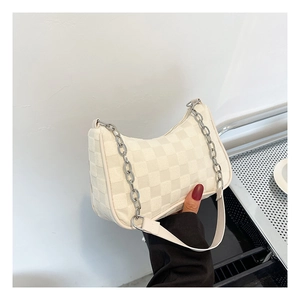 Close-up of cream checkerboard underarm bag with silver chain strap and modern texture