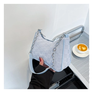 Detail of light blue checkered crescent bag with chunky silver chain and leather strap