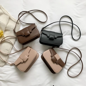 Minimalist square crossbody bags in four solid colors displayed on white bedding