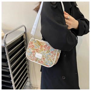 Close-up of floral jacquard underarm bag with white leather trim and Fashion logo label