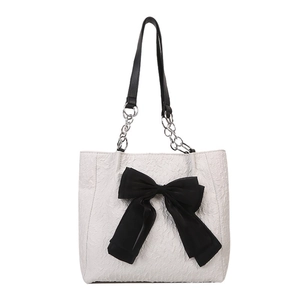 Grand sac cabas blanc texturé avec un nœud noir et une bandoulière en chaîne