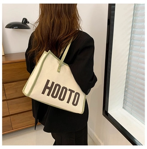 Détail du sac cabas en toile avec imprimé HOOTO et passepoil vert clair élégant