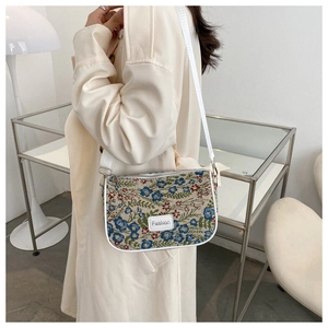 Detail of floral embroidery on a retro shoulder bag with an adjustable wide strap