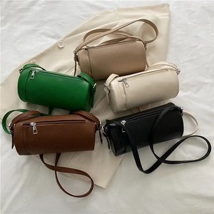 Chic cylindrical crossbody bags in five colors displayed on neutral fabric