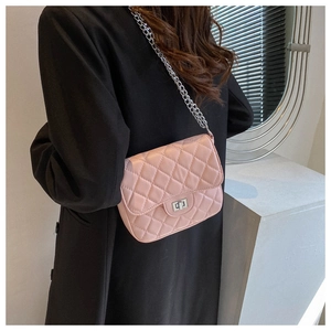 Close-up of pink quilted crossbody bag with silver chain strap and metal turn-lock