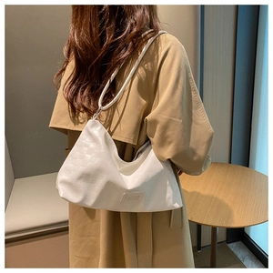 Detail of cream white woven texture shoulder bag with Fashion label and zipper closure