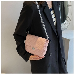 Detailed view of pink quilted crossbody bag texture and silver metal turn-lock closure