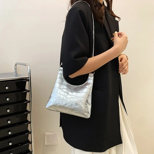 Silver crocodile pattern hobo bag worn on shoulder by model with metallic gloss finish