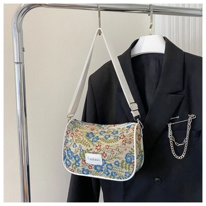 Detailed view of retro floral print fabric and Fashion logo on underarm shoulder bag
