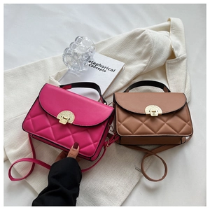 Close-up of quilted crossbody bags with golden shell clasps in rose red and brown