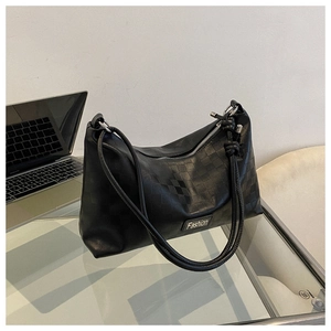 Close-up of black checkered embossed shoulder bag with knot detail and metal logo