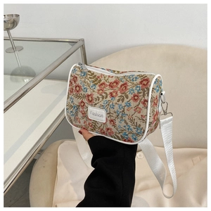 Detail of vintage floral jacquard fabric and white PU piping on a small crossbody bag