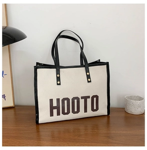 Détail des finitions en cuir contrasté et lettrage HOOTO sur grand sac cabas