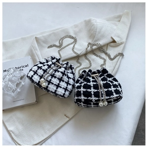 Close-up of tweed plaid bucket bags with silver chain straps and pearl drawstring details