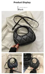 Detail of black quilted leather handbag with circular handle and crossbody strap