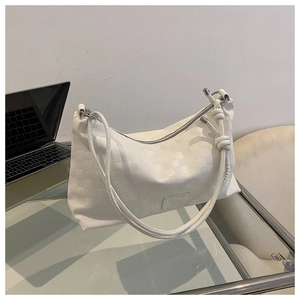Close-up of a white waffle texture crossbody bag with a Fashion leather label