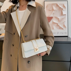 Minimalistische weiße Umhängetasche mit Krokostruktur und Goldkette am Model