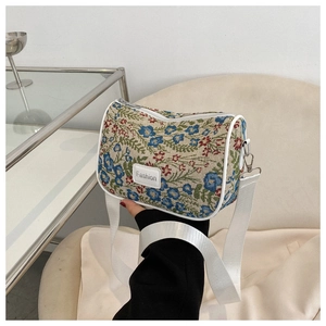 Detail of vintage floral pattern shoulder bag with adjustable strap and fashion label