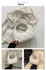 Detail view of white quilted dumpling bag featuring top handle and leather strap