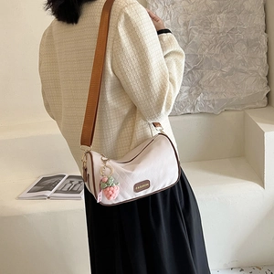 Schicke beige Stepp-Umhängetasche mit braunem Rand und süßem Erdbeer-Plüsch-Anhänger