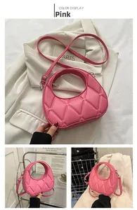 Detail view of pink quilted crescent bag with smooth zipper and faux leather texture