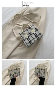 Détail du sac cabas en tweed noir et blanc avec poignées et bandoulière en cuir crème