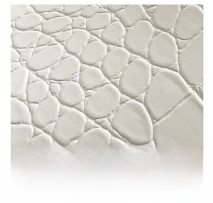 Gros plan macro sur la texture gaufrée crocodile en cuir synthétique blanc crème
