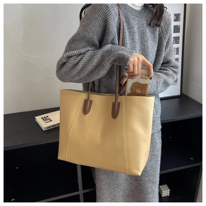 Detail shot of large beige tote bag interior showing spacious storage for a phone