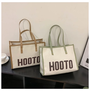 Détail de deux sacs cabas en toile marron et vert avec poignées en cuir et rivets métalliques