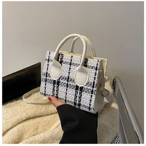 Gros plan du mini sac cabas en tweed à carreaux noir et blanc avec poignée en cuir PU