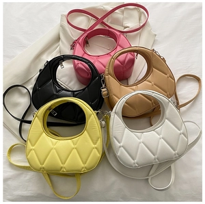 Detail of five colorful dumpling-style bags with diamond quilting and cut-out handles
