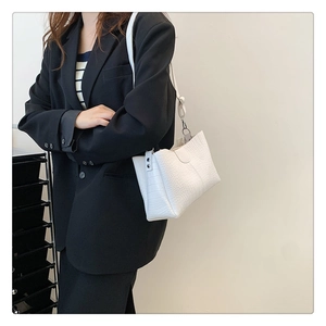 Détail du sac à bandoulière blanc motif crocodile avec boucle argentée et lanière
