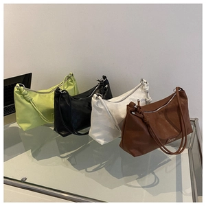 Detail view of four minimalist shoulder bags in green, black, white, and brown PU leather