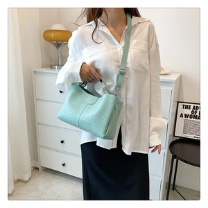 Détail du sac à main vert menthe à motif crocodile avec bandoulière réglable