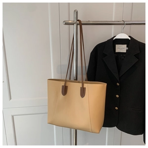 Macro detail of high-quality stitching and brown shoulder strap on beige tote bag