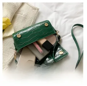 Green crocodile pattern baguette bag showing interior space for phone and makeup