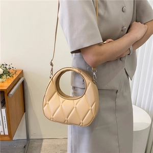 Beige quilted hobo bag with circular cutout handle and detachable crossbody strap