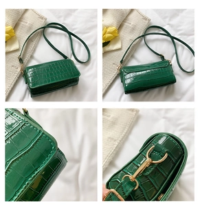 Detailed views of dark green faux leather baguette bag with crocodile embossed texture