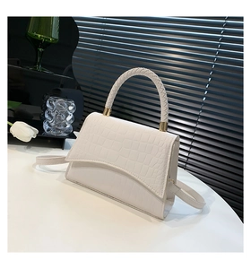 Detailed shot of white faux crocodile texture leather bag with braided handle