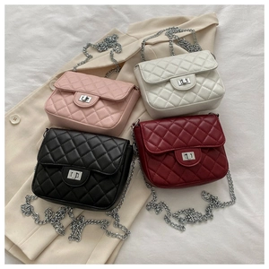 Flat lay of four quilted chain bags in pink, white, black and burgundy colors