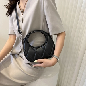 Fashionable black quilted crescent bag with unique round handle and adjustable strap