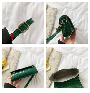 Detail view of dark green croc-embossed baguette bag with gold metal buckle and gray lining