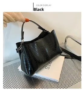 Détail du sac cabas noir à motif crocodile avec des boucles en métal argenté brillant