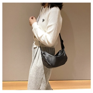 Minimalist black crescent crossbody bag made of durable nylon shown on a model